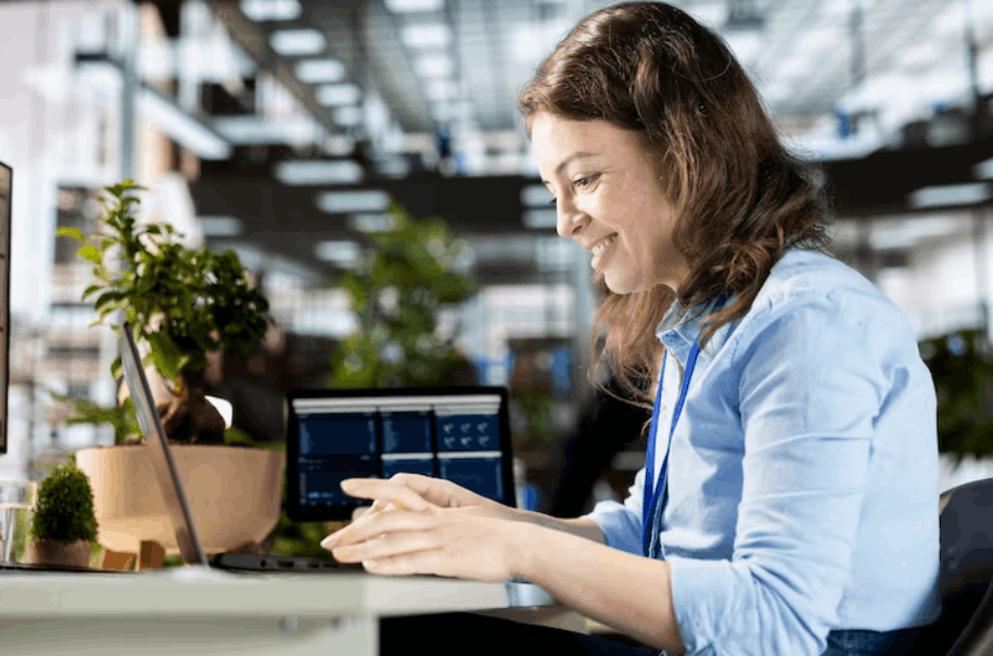 Office worker using a laptop at a desk in a modern workplace