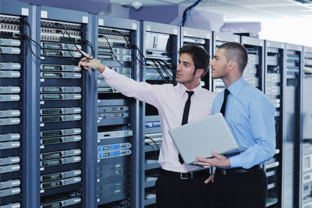 IT specialists inspecting and managing network hardware inside a commercial server room