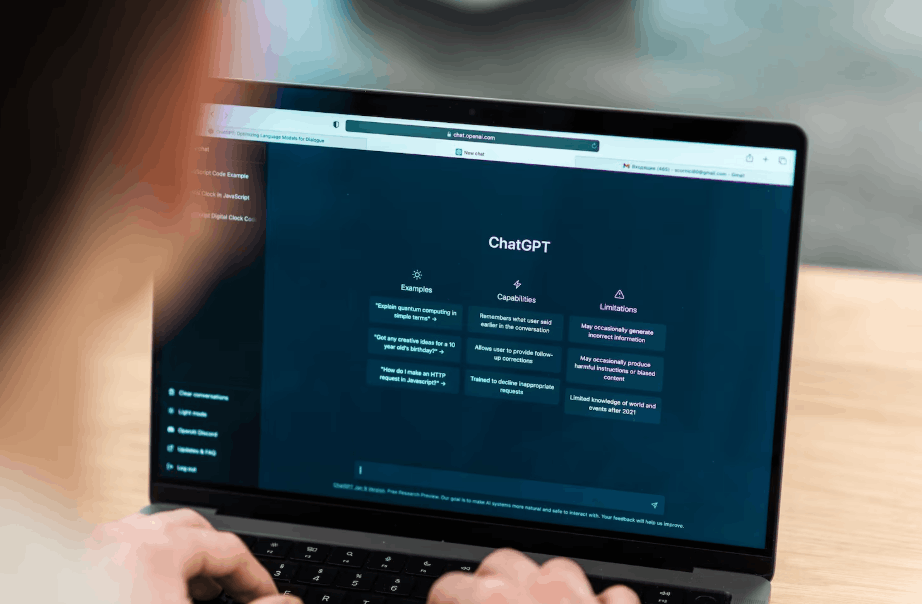 Person using a laptop displaying the ChatGPT interface on screen in a business