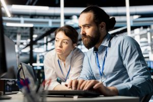 IT engineers analysing system data and running diagnostics in a data centre environment.