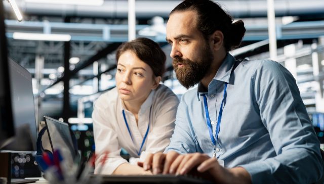 IT engineers analysing system data and running diagnostics in a data centre environment.