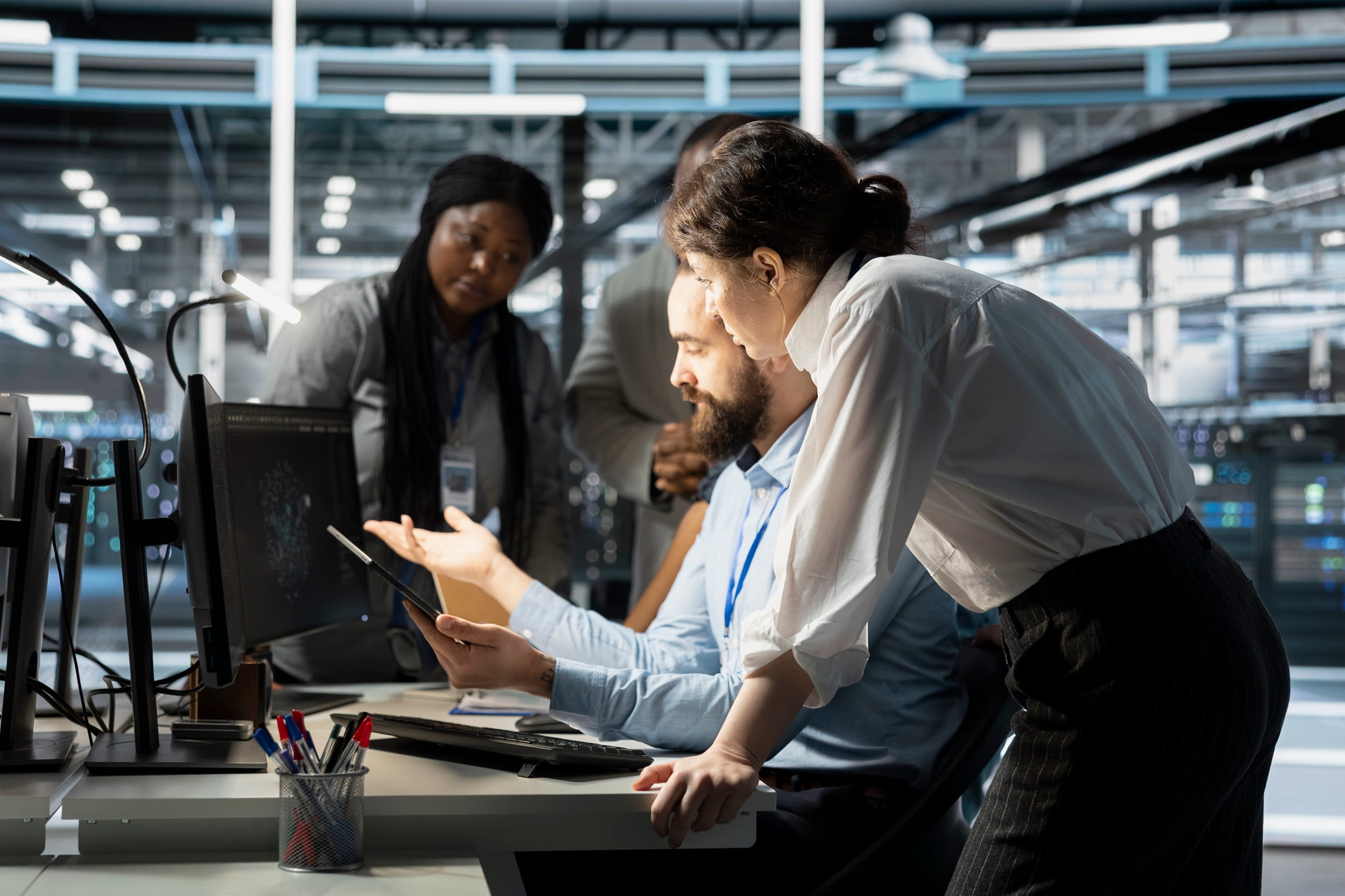 IT support team reviewing system performance and diagnostics together in a data centre.