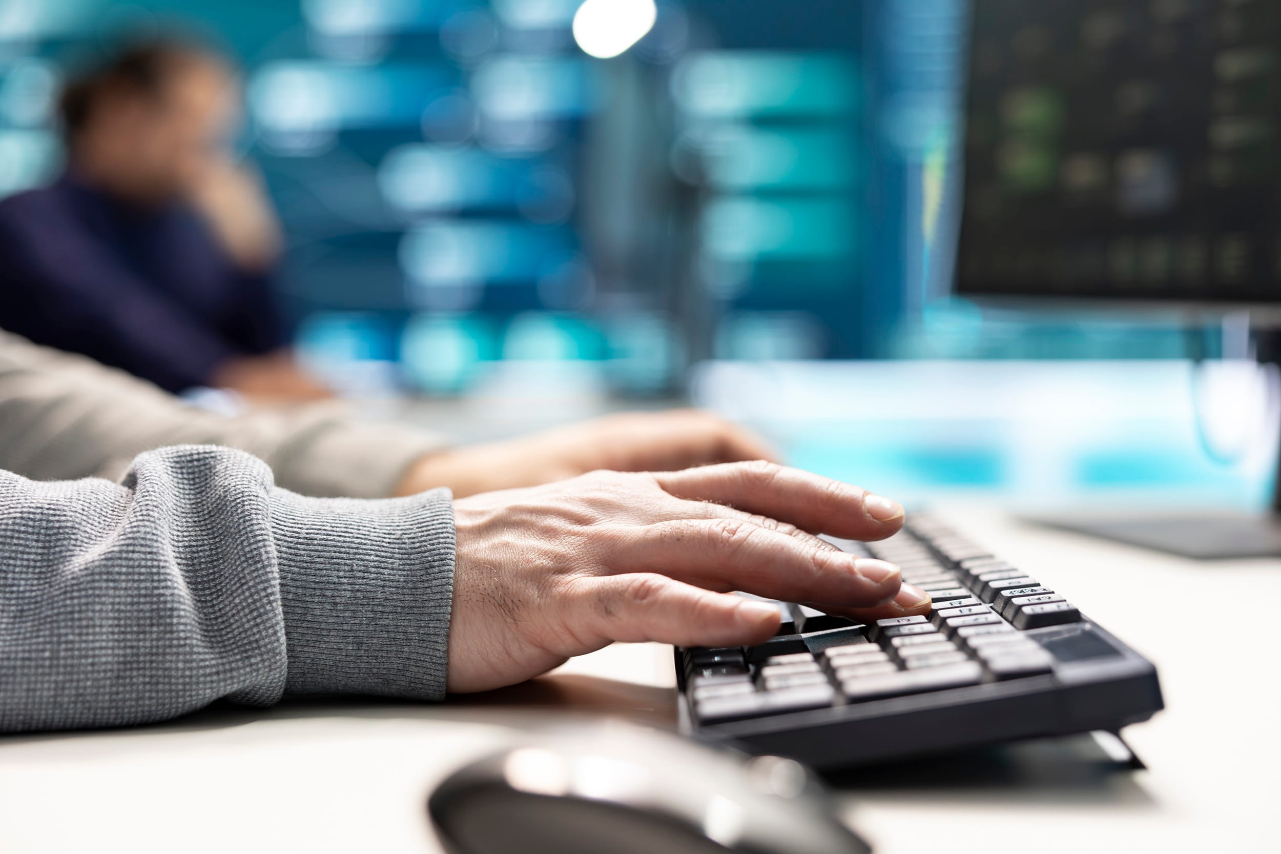 IT specialist monitoring computer systems from a workstation.
