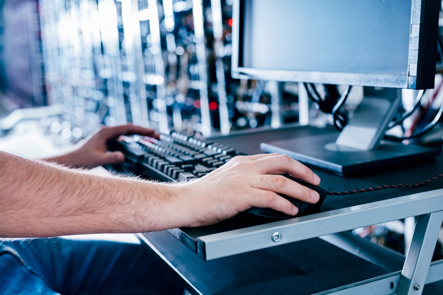 Technician using a computer to monitor servers in a data centre.