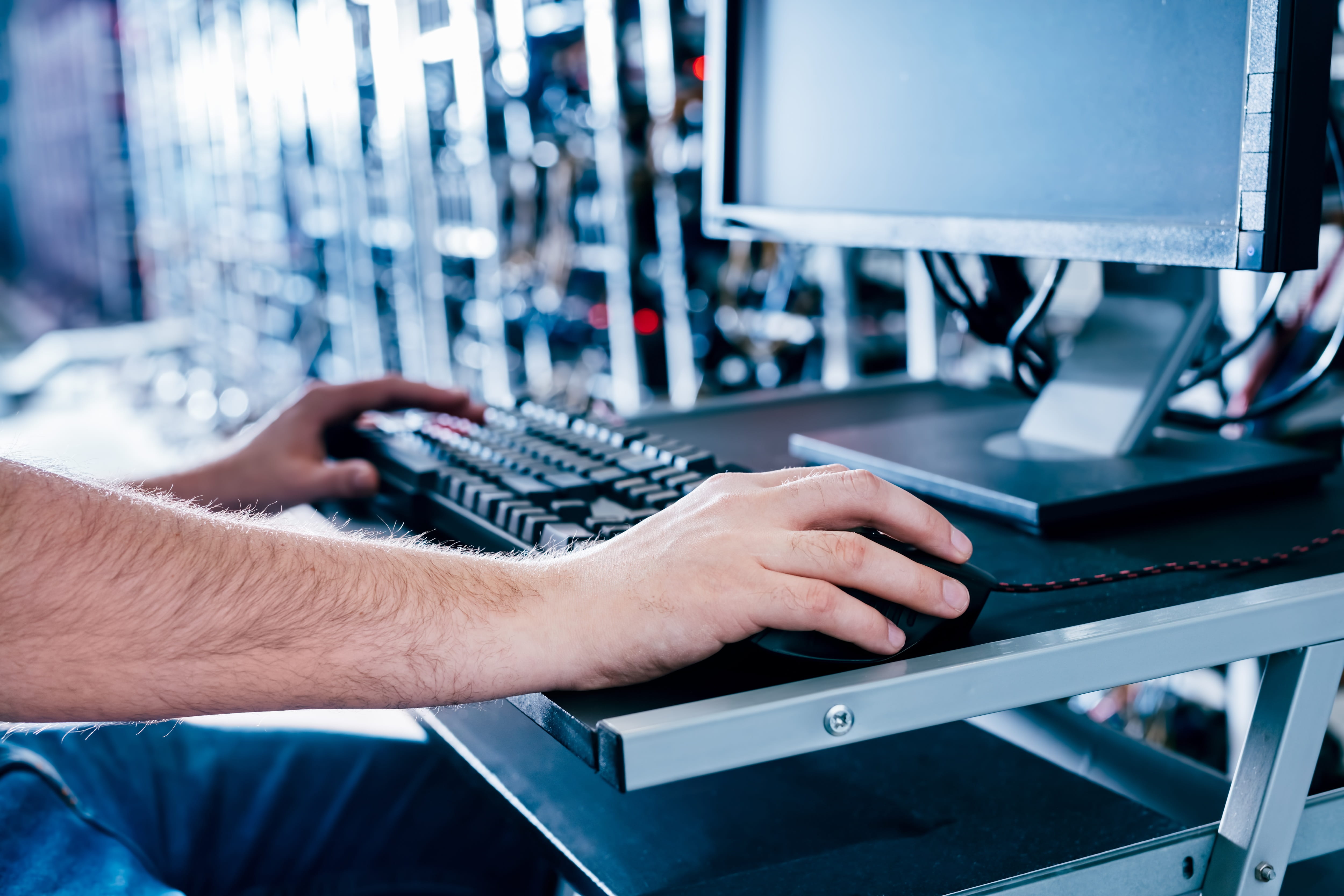 Technician using a computer to monitor servers in a data centre.