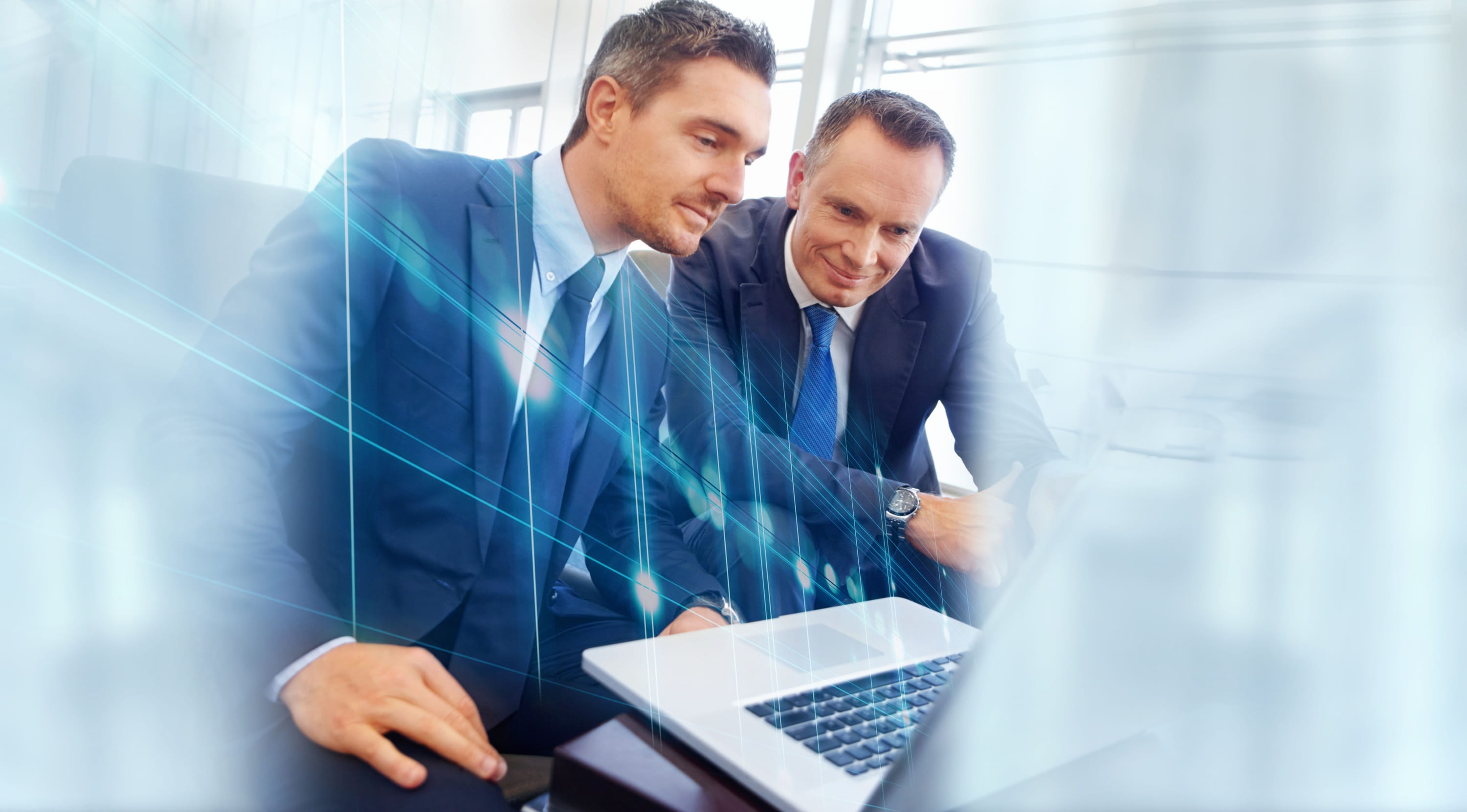 Two business professionals reviewing information on a laptop during an IT consultation.