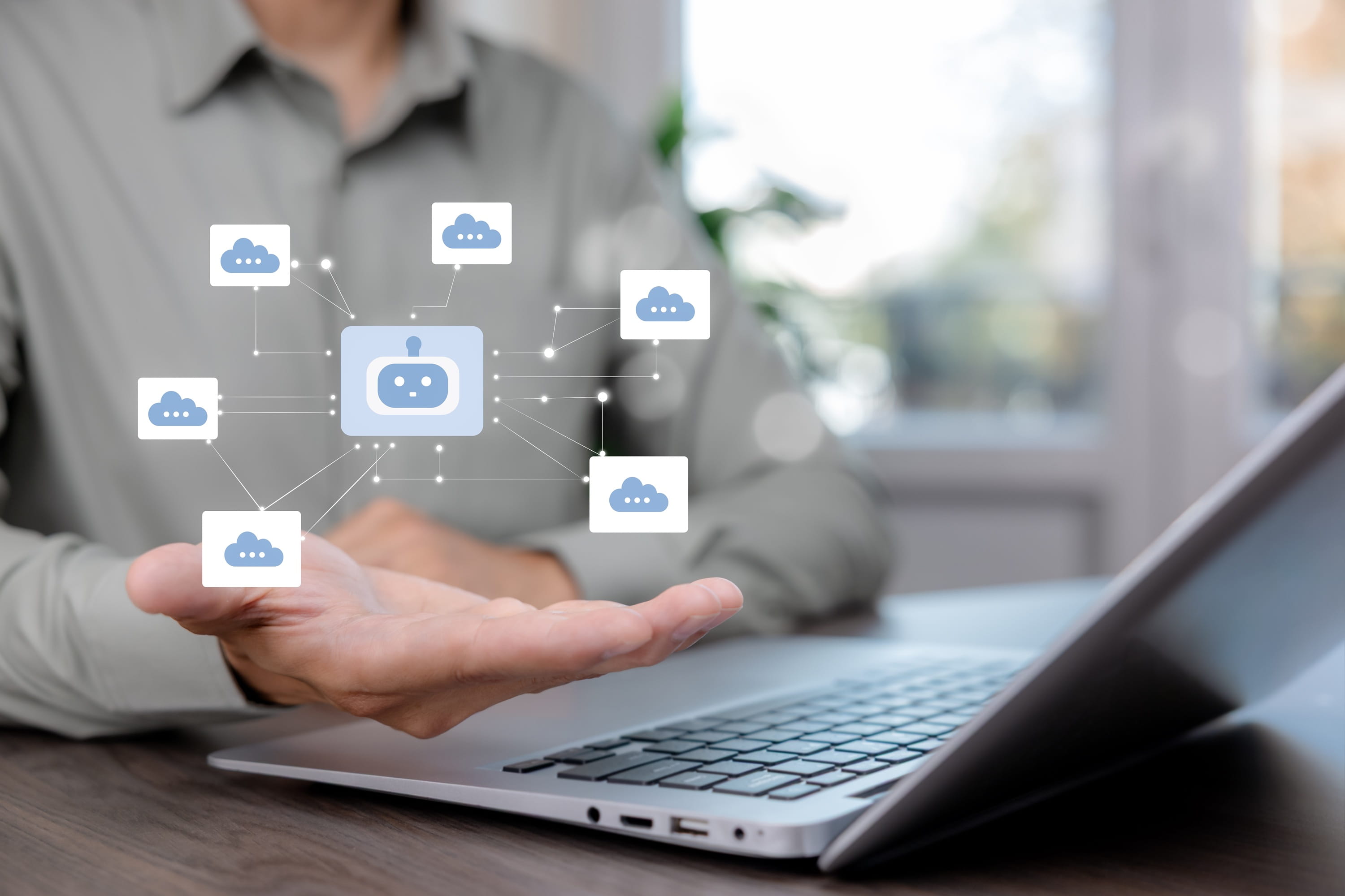 Business professional using a laptop with connected cloud storage icons.